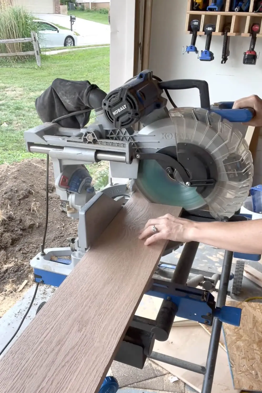 Cutting oak boards to size for building a DIY fireplace mantel, using a miter saw for precise measurements.